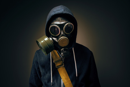 businessman wearing gas mask in the dark background