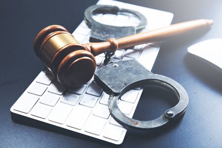 handcuffed with judge on computer keyboardの写真素材