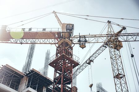 Tower Crane lifting heavy load under skyの写真素材