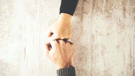 woman and man fists on wooden tableの写真素材