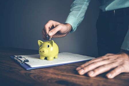 man hand  coins with piggy bank on document