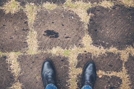 man black shoes on asphaltの写真素材