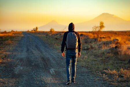 man in road at sunset