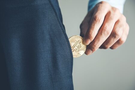 business man pocket bitcoin on gray backgroundの写真素材