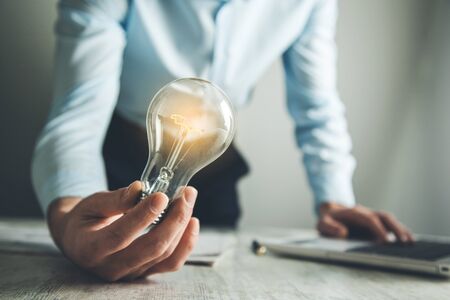 man hand light lulb with graph in office