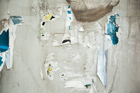 Colorful torn posters on grunge old walls