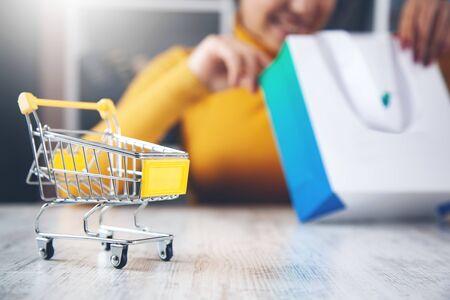 woman hand on shopping bag with basket on tableの写真素材