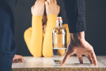 man hand alcohol with sad  womanの写真素材