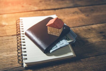 house model with  wallet on notepad on deskの写真素材
