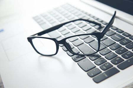 glasses on the keyboard backgroundの写真素材