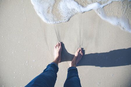 young man feet on beachの写真素材