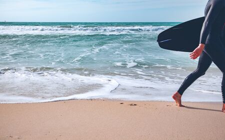 Young surfer with board on the beachの写真素材