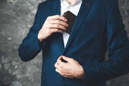 man hand holding wallet on dark backgroundの写真素材