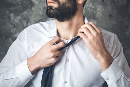 business man remove tie on dark backgroundの写真素材