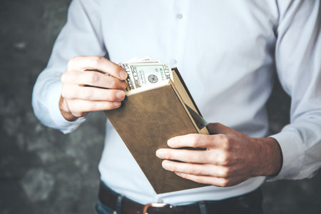 man hand holding money on the bookの写真素材