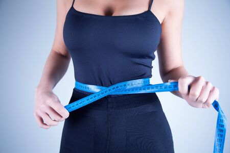 woman with measuring  on gray background .の写真素材