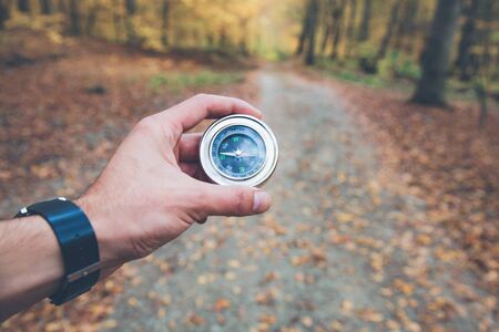 traveler man hand compass in autumn forestの写真素材