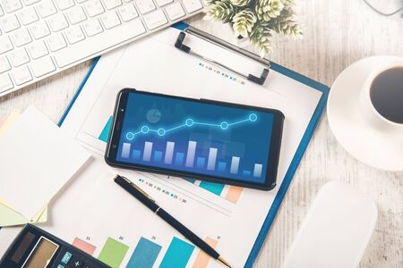 graph on phone screen on graph on desk