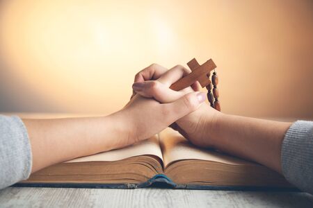 woman hand wooden cross with book on tableの写真素材
