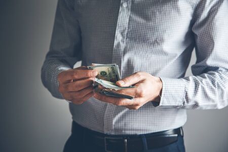 young business man hand money  on grey background