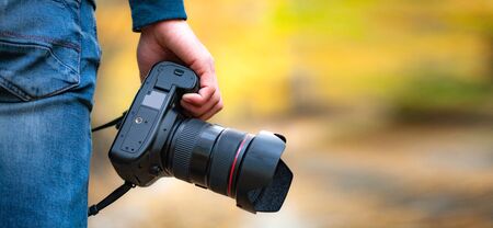 man hand camera in the autumn forestの写真素材