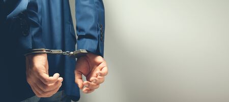 man hand handcuffs in backon grey backgroundの写真素材