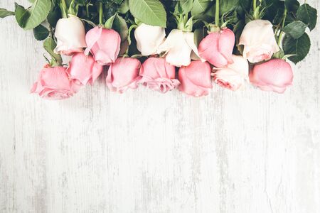 pink roses on the wooden desk backgroundの写真素材