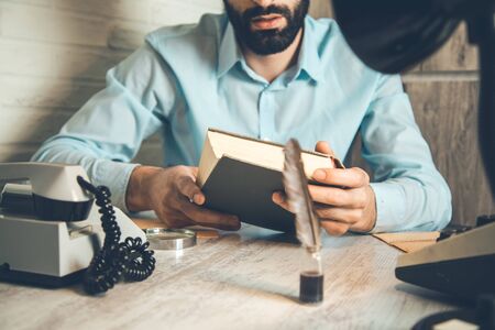man hand holding book on desk backgroundの写真素材