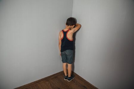 sad baby on the gray wall backgroundの写真素材