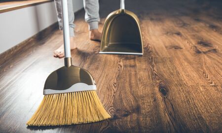 woman hand broom dustpan on the groundの写真素材