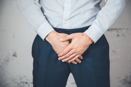 Man holding his urethra in pain on abstract backgroundの写真素材