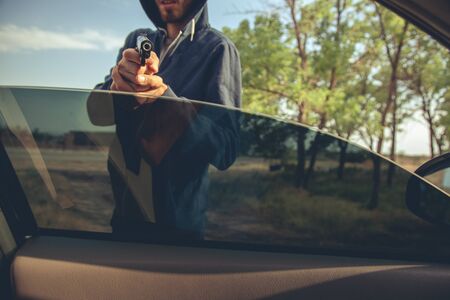 man hand gun in car in natureの写真素材
