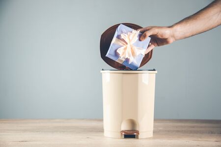 

man hand holding gift box on trash の写真素材