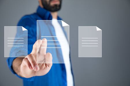 man touching files in screen on grey background