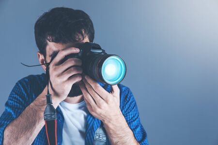 young man hand photo camera on grey backgroundの写真素材
