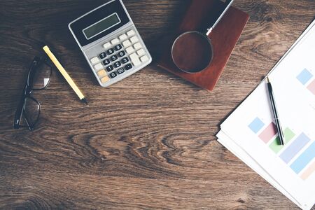graph with calculator and magnifier on deskの写真素材