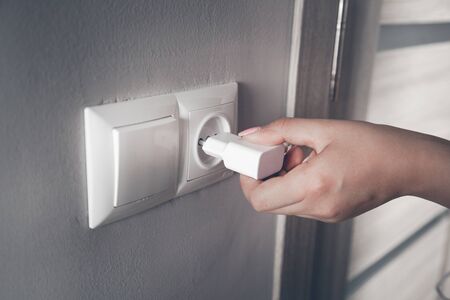 woman hand charger with plug in home