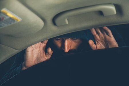 the thief looks inside the car at nightの写真素材