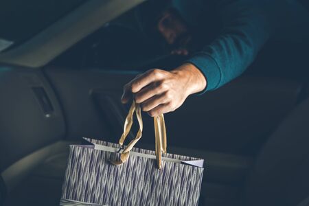 a thief steals bag in car in streetの写真素材