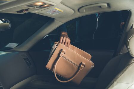 a thief steals bag in car in street