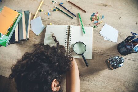 sleeping student on notepad in desk  backgroundの写真素材
