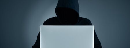 hacker hand computer and codes on grey wall backgroud