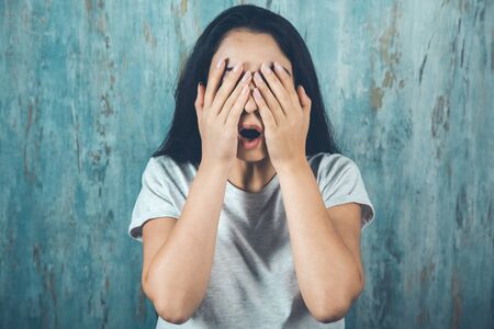 woman closed  eye in hand on abstract backgroundの写真素材