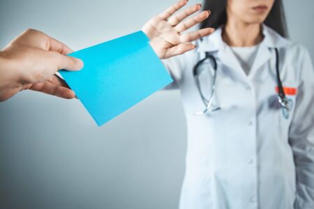Doctor no in bribe on gray background