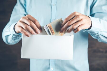 man hand holding money with letter on dark background