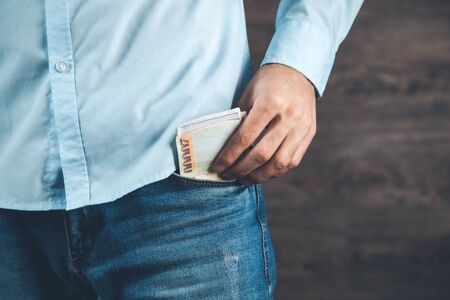 man hand holding money on the pocketの写真素材