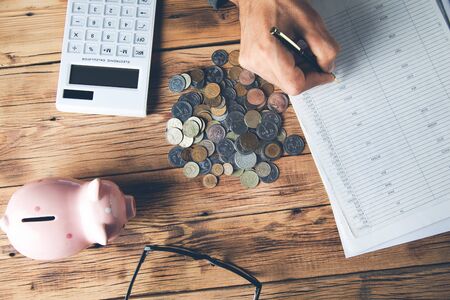 man hand coins with document and piggy bank on desk