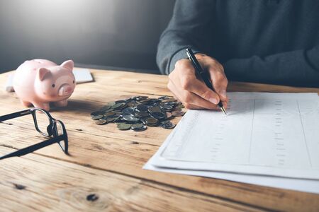 man hand document and piggy bank on desk