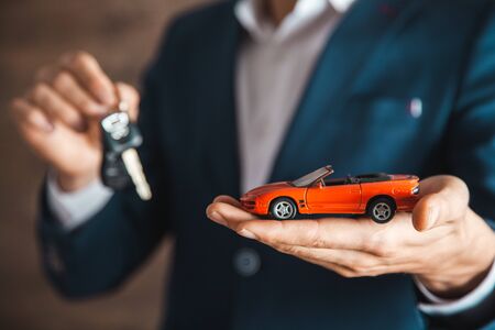 man hand car model with key on dark backgroundの写真素材