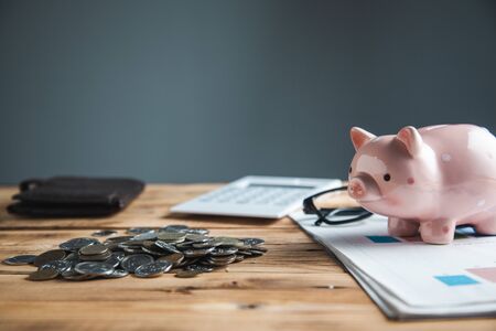 coins with piggy bank on desk background